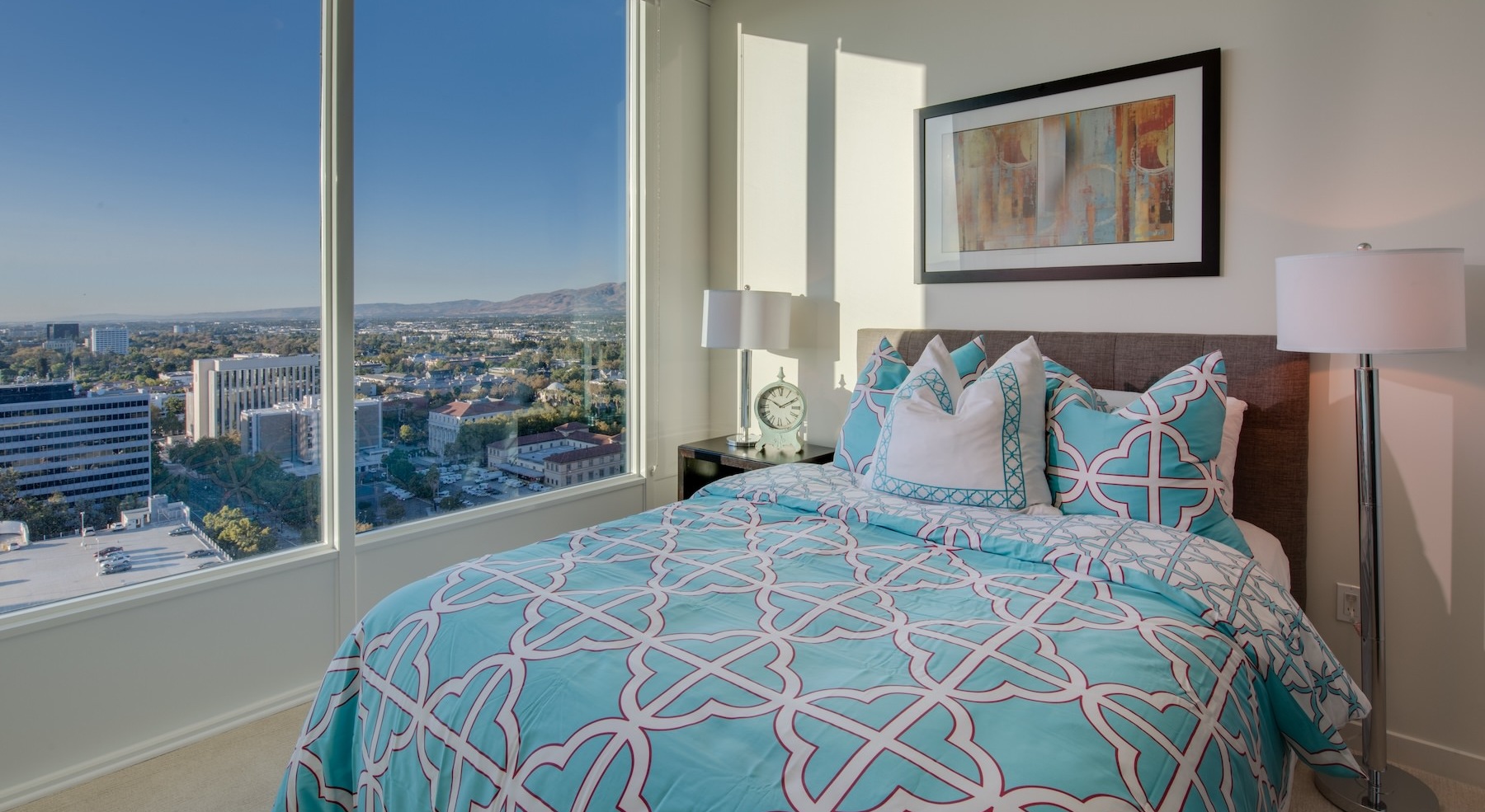 bedroom with a large window and a view of a city