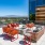 a deck with chairs and tables on it and a view of the city